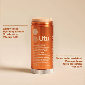 Orange sunscreen stick with 'Utu' branding on a beige background