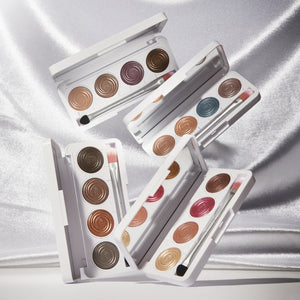 Set of makeup palettes with various colors on a satin surface