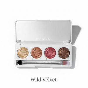 Makeup palette with four circular shades and a brush on a white background