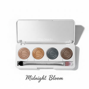 Makeup palette with four circular shades and a brush on a white background