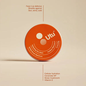 Orange container of Utu lip balm on a beige background
