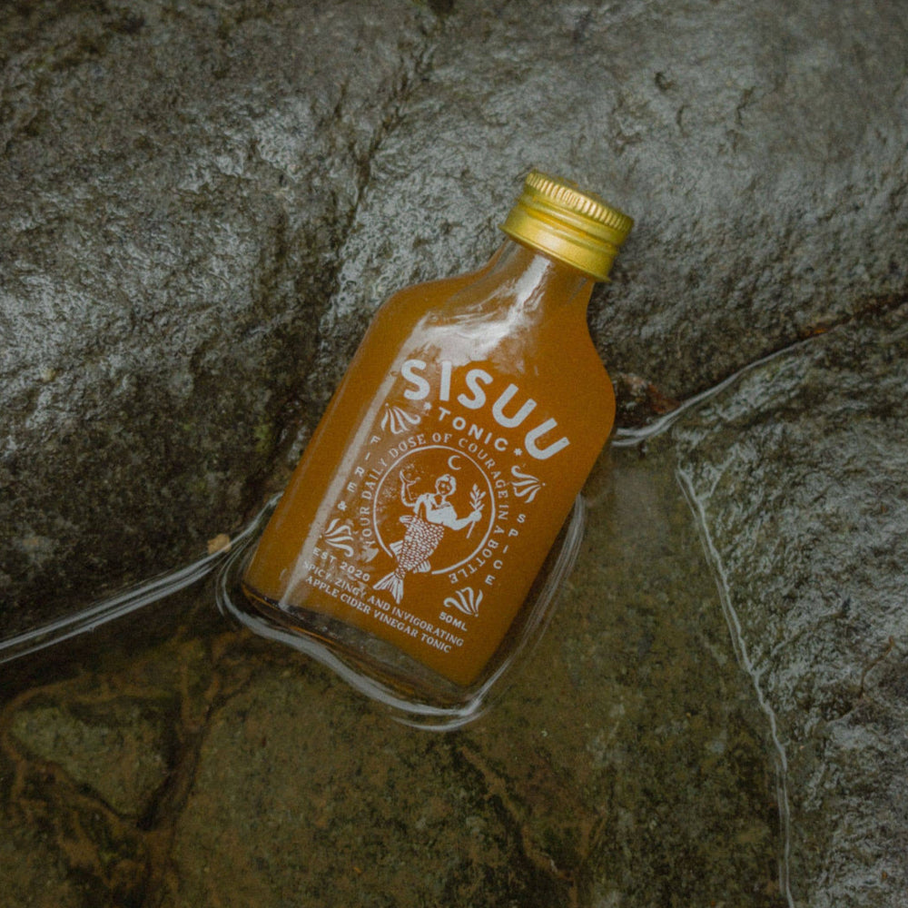 Small bottle of Sisu tonic on a stone surface