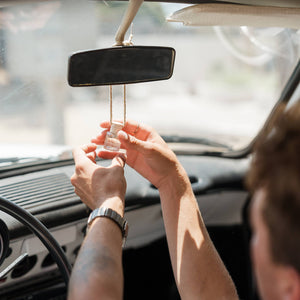 Person adjusting a car mirror inside a vehicle