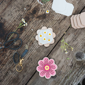 Floral designs on fabric with scissors and flowers on a wooden surface