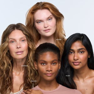 Four women with different hairstyles and skin tones standing together on a light gray background.
