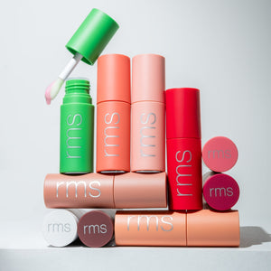 Colorful RMS beauty products on a light gray background