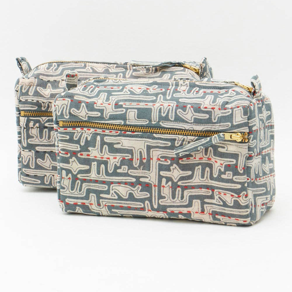 Patterned toiletry bag with gold zippers on a white background