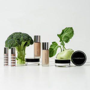 Cosmetic products with broccoli and other green vegetables on a white background