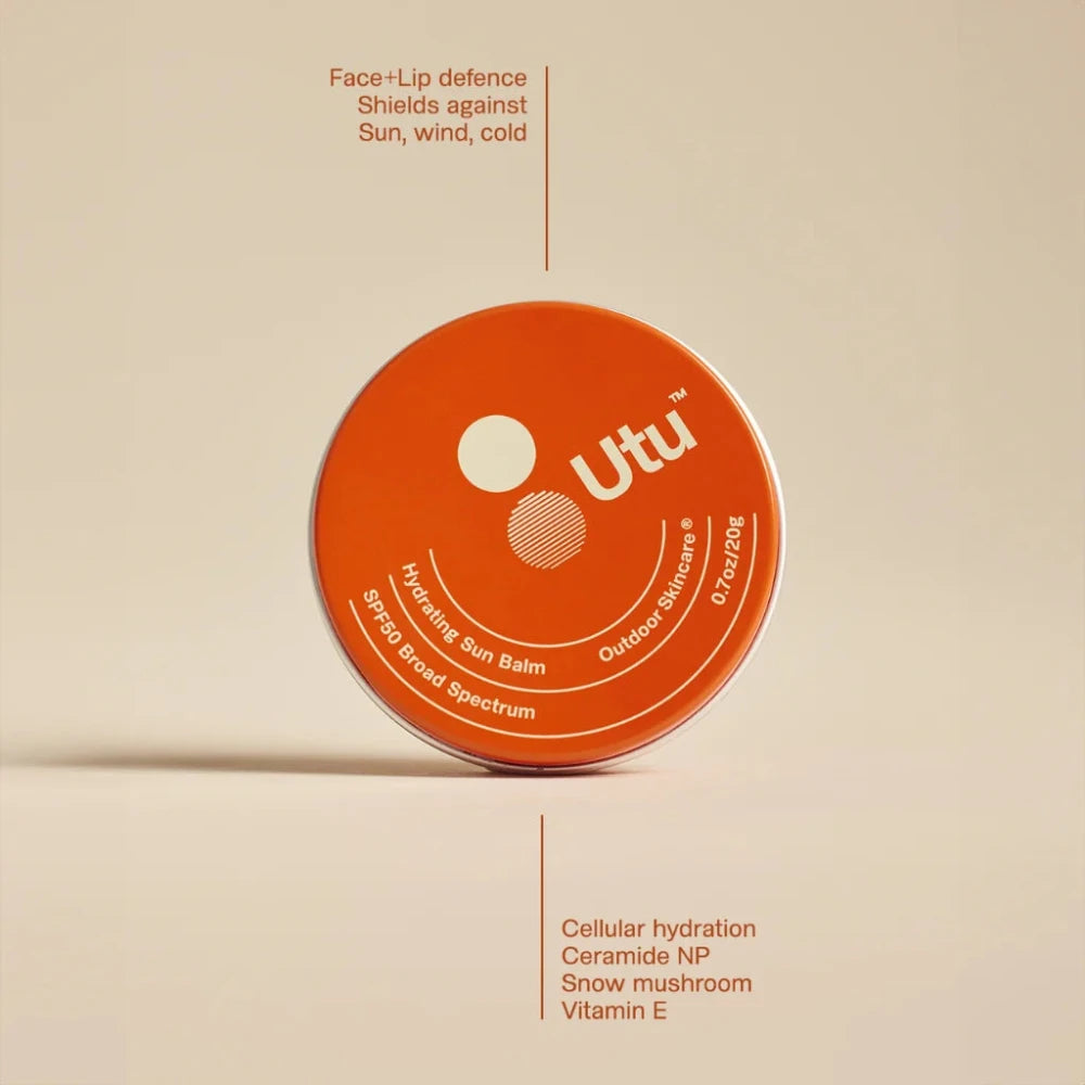Orange container of Utu lip balm on a beige background