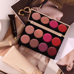 Makeup palette with lipsticks and a tube of cream on a magazine background