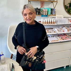 Person holding a makeup bag with products in a beauty store setting