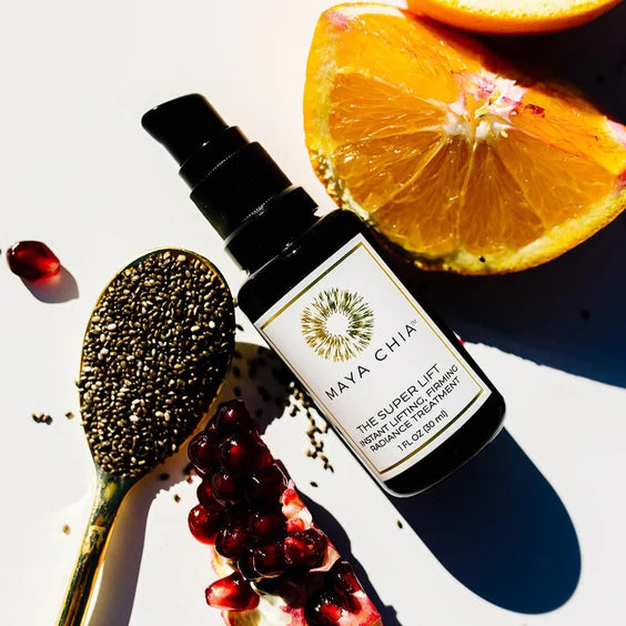 a spoonful of chia seeds and bottle of skincare sitting next to an orange slice