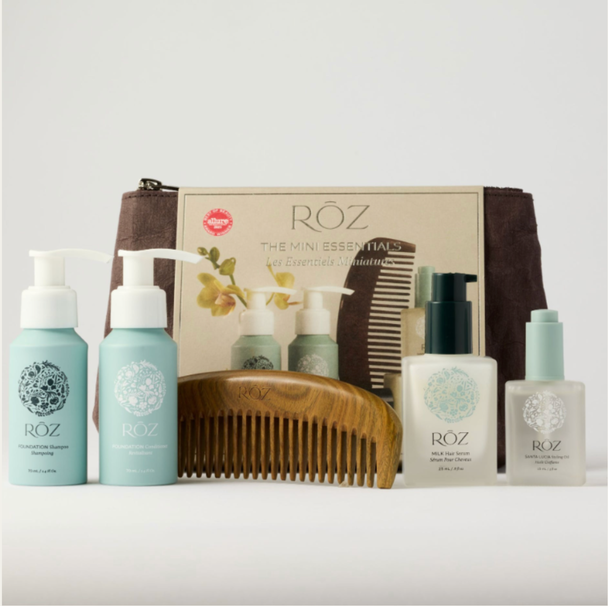 Röz hair care product set with bottles, a comb, and a pouch on a light gray background