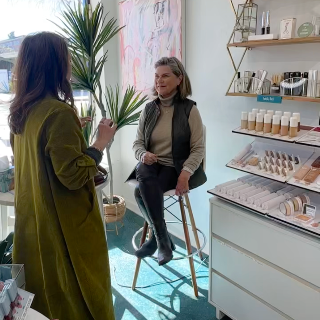 Holly giving makeup advice to a middle aged customer in the beauty area of the shop.