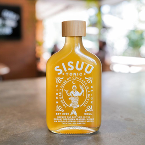 Yellow bottle of SISUU Tonic with a wooden cap on a blurred background