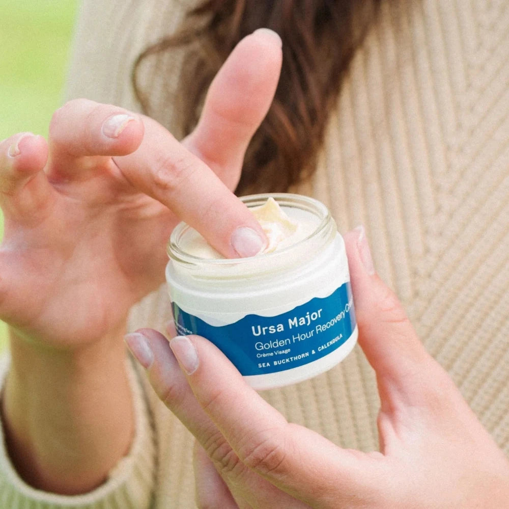 woman holding jar of yellow cream