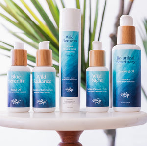 Collection of WildCraft skincare products on a white surface with a blurred natural background