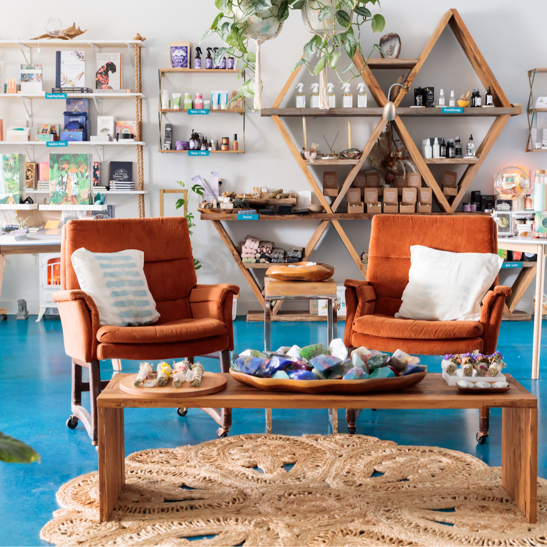 Wildcraft Charleston retail shop interior featuring Modern interior design with orange chairs, wooden coffee table, and shelves filled with books and decor.