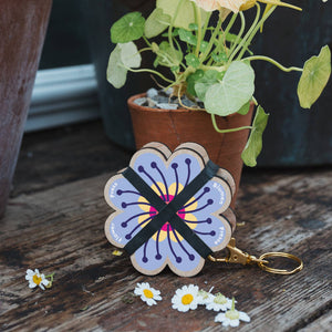 Floral keychain with a pot of flowers on a wooden surface