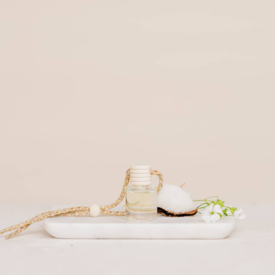 Small glass jar with a white cap on a marble tray with a beige background