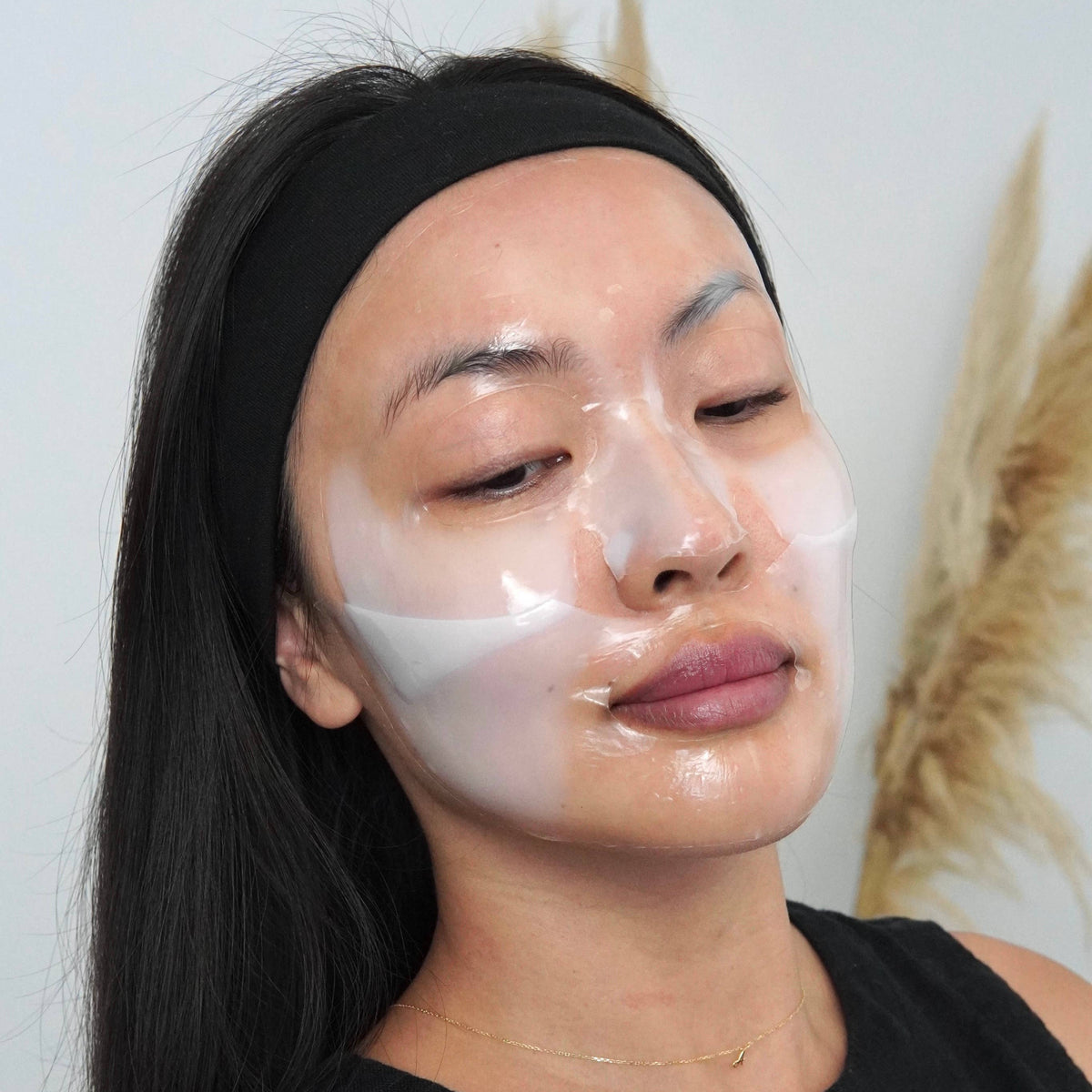 Person applying a face mask with a neutral background