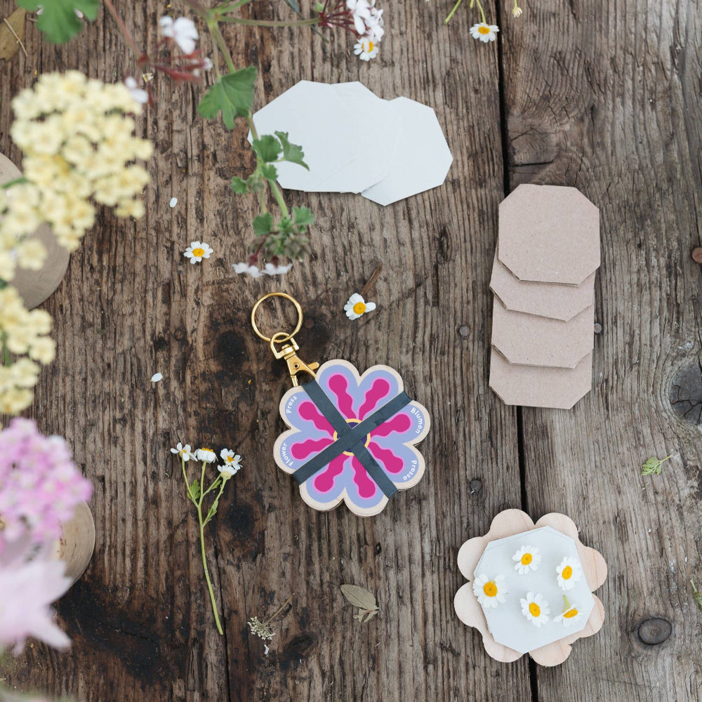 Decorative keychain and stickers on a wooden surface with flowers