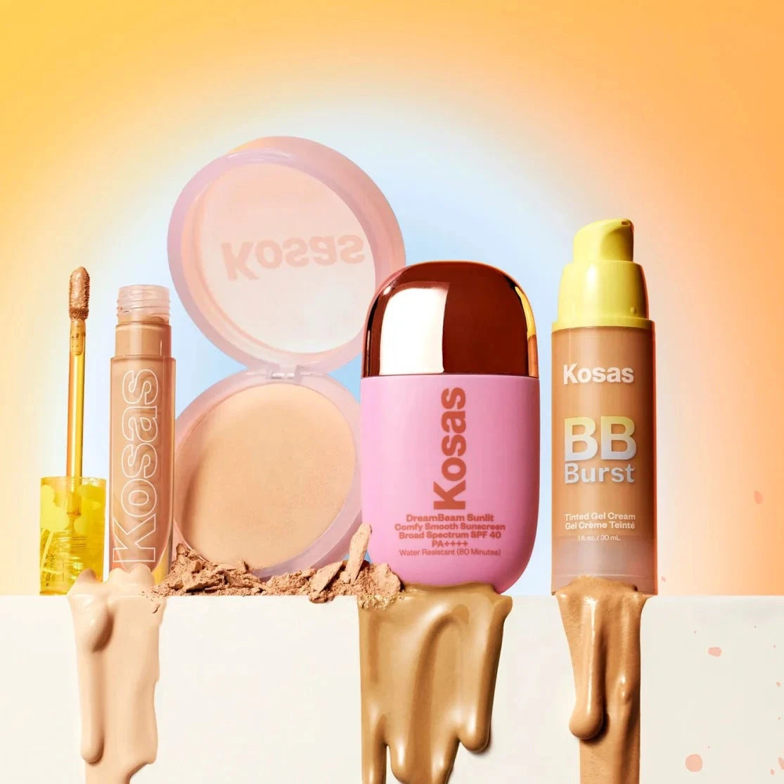 four makeup products sitting in a row - a concealer, pressed powder, sunscreen and foundation