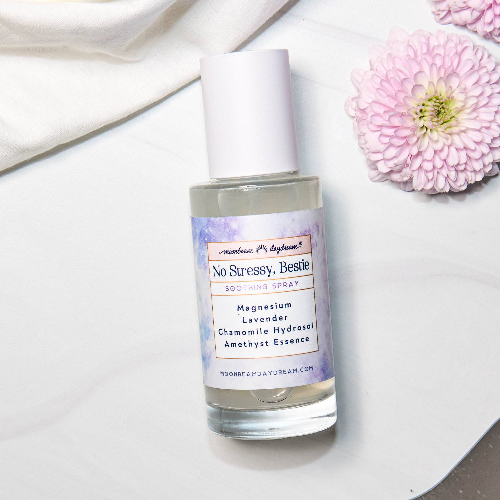 Skincare bottle labeled 'No Stressy, Bestie' with flowers on a light background